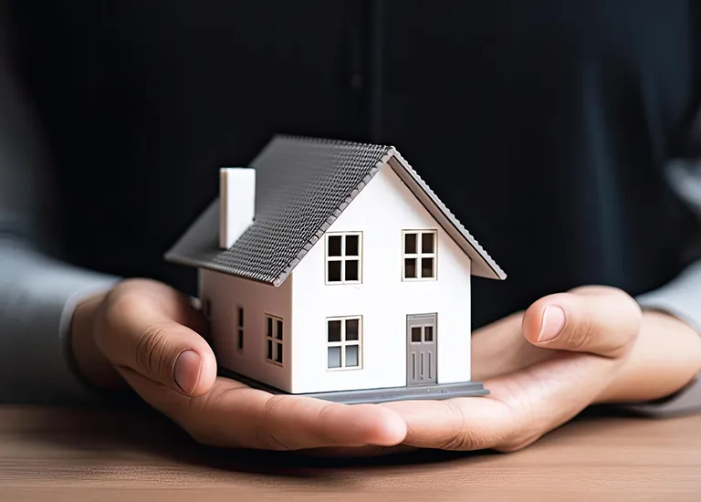 Mãos protegem a miniatura de uma casa